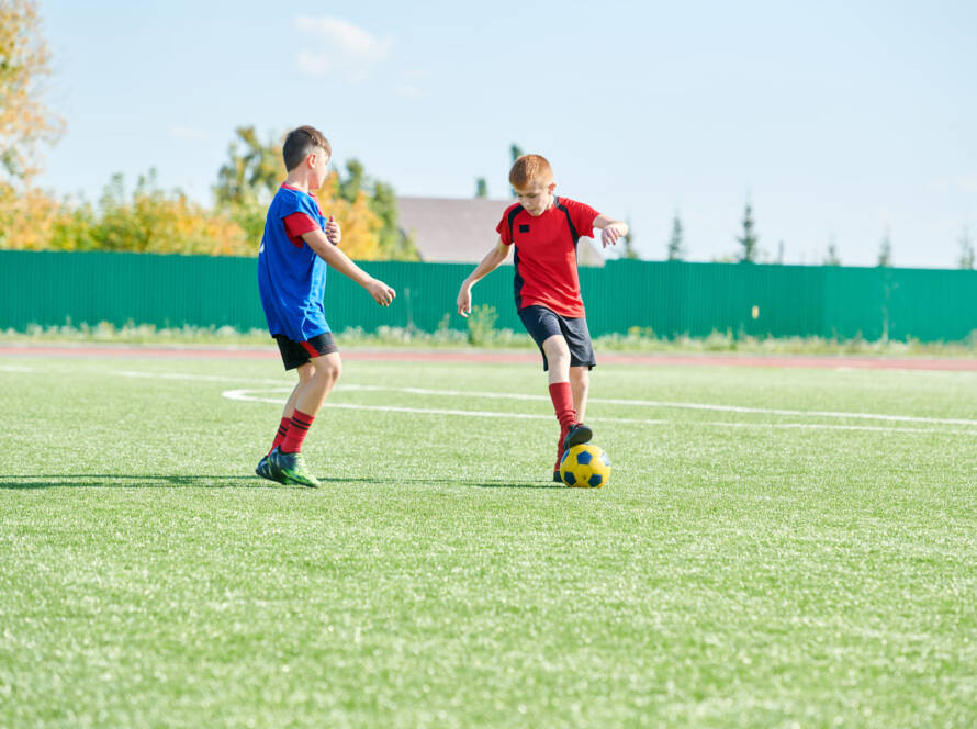 niños jugando al futbol en campo de futbol