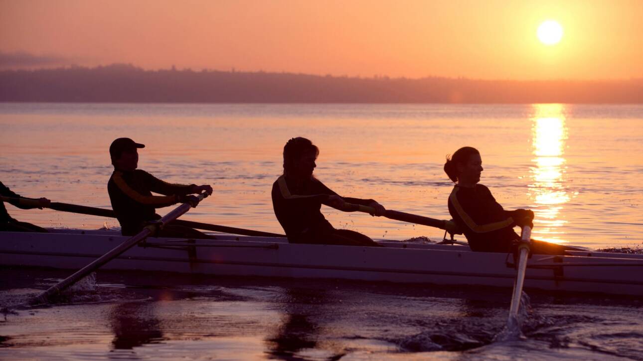 mujeres remando en el atardecer